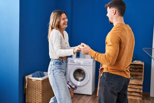 一对年轻夫妇在洗衣房自信地微笑着跳舞 — 图库照片