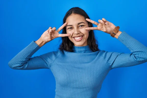 Young Brazilian Woman Standing Blue Isolated Background Doing Peace Symbol — Stockfoto