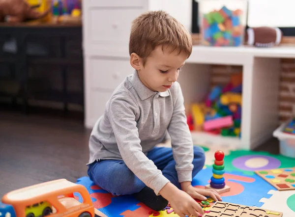 愛らしい幼児遊びとともに数学ゲーム座っています床に幼稚園 — ストック写真