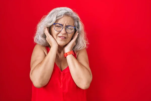 Middle Age Woman Grey Hair Standing Red Background Covering Ears — Stockfoto