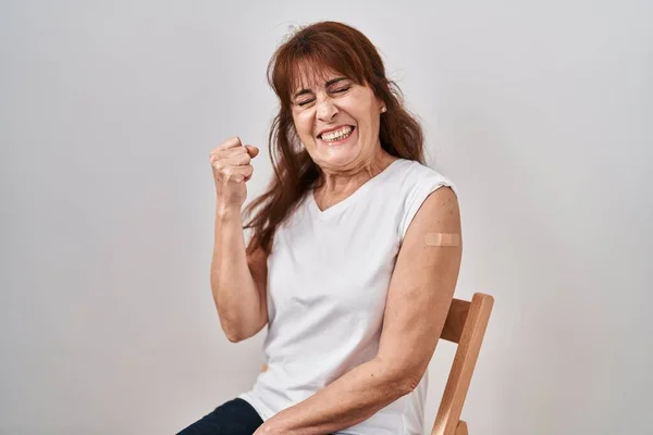 Middle Age Hispanic Woman Getting Vaccine Showing Arm Band Aid — Zdjęcie stockowe