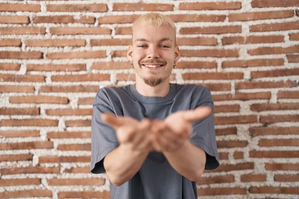 Νεαρός Καυκάσιος Άνδρας Στέκεται Πάνω Από Τούβλα Τοίχο Χαμογελώντας Χέρια — Φωτογραφία Αρχείου