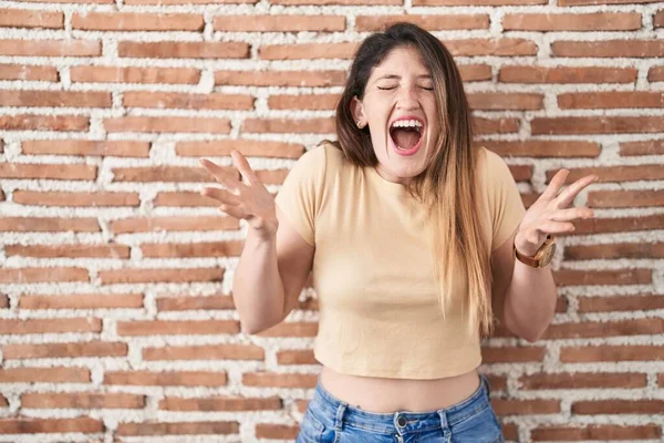 Jonge Brunette Vrouw Staat Bakstenen Muur Vieren Gek Gek Voor — Stockfoto