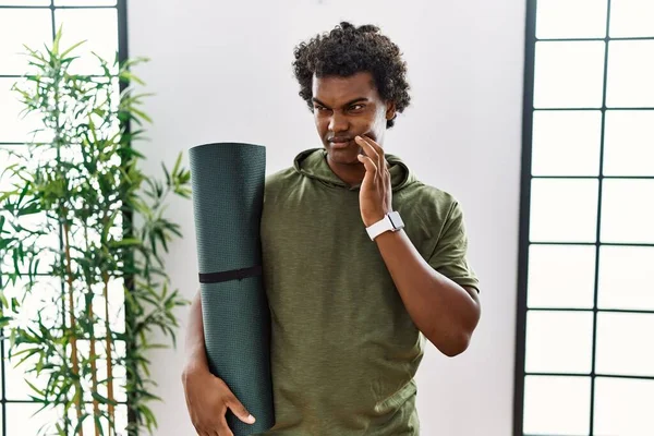 African Man Curly Hair Holding Yoga Mat Studio Touching Mouth — Stockfoto