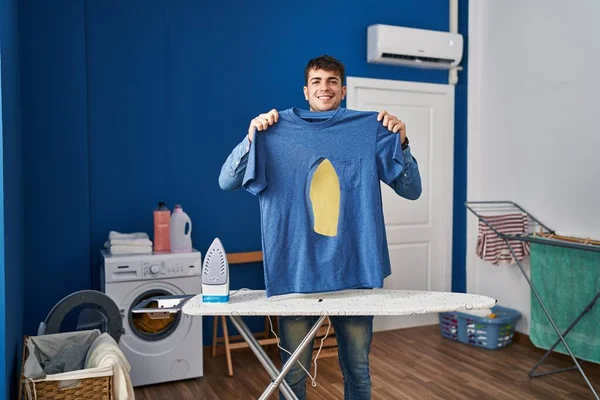 Young Hispanic Man Ironing Holding Burned Iron Shirt Laundry Room — Foto Stock