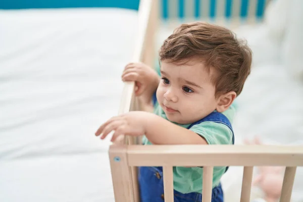 可爱的惊慌失措的幼儿站在卧室的摇篮上 — 图库照片