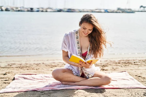 Young Beautiful Hispanic Woman Tourist Reading Book Sitting Sand Beach — Zdjęcie stockowe