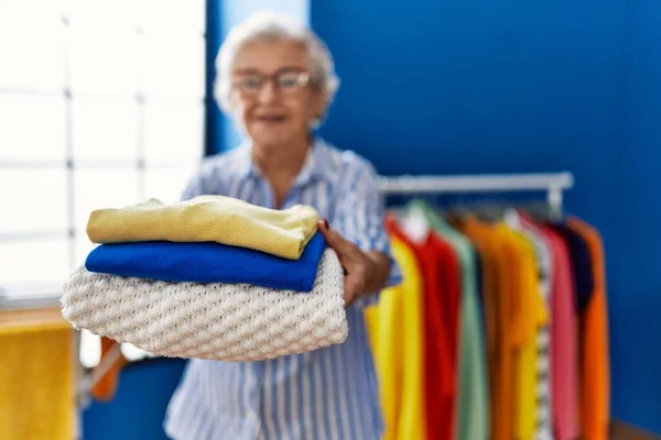 Starší Šedovlasá Žena Úsměvem Sebevědomě Drží Složené Oblečení Prádelně — Stock fotografie
