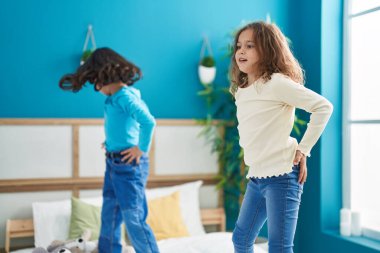 Two kids smiling confident dancing on bed at bedroom