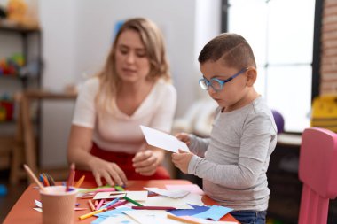 Öğretmen ve yeni yürümeye başlayan çocuk ana okulunda el sanatları dersi alıyor.