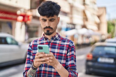 Sokakta akıllı telefon kullanan genç bir İspanyol.