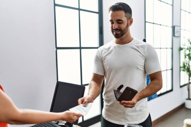 Genç İspanyol müşteriler, giyim mağazasından kredi kartıyla satın alıyorlar.