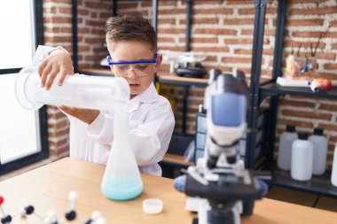 Sevimli İspanyol öğrenci laboratuvar sınıfında test tüpüne sıvı döküyor.