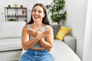 Genç ve güzel İspanyol kadın evdeki kanepede oturan sağırlarla iletişim kuruyor.