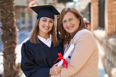 Mother and daughter hugging each other celebrating graduation at university