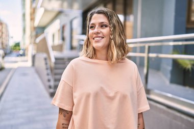 Sokakta kendinden emin gülümseyen genç İspanyol kadın.