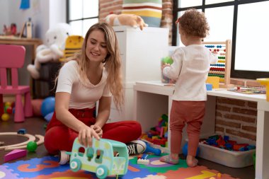 Teacher and toddler playing at kindergarten