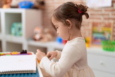 Anaokulunda kağıt kesen sevimli kız.