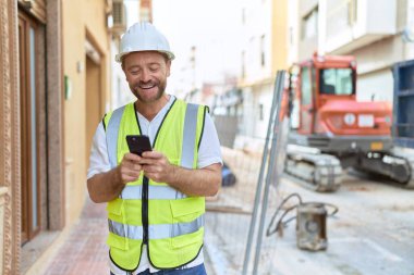 Middle age man architect smiling confident using smartphone at street