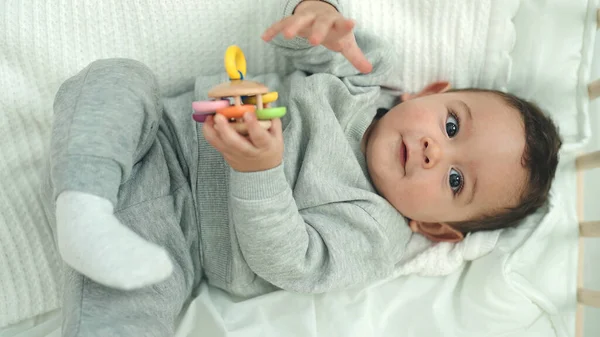 Sevimli Spanyol Bebek Yatakta Uzanmış Yatak Odasında Oyuncaklarla Oynuyor — Stok fotoğraf