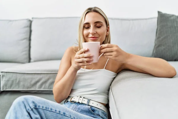 Junge Blonde Frau Lächelt Selbstbewusst Und Trinkt Hause Kaffee — Stockfoto