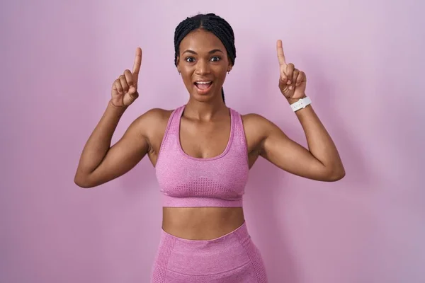 African American Woman Braids Wearing Sportswear Pink Background Smiling Amazed — Zdjęcie stockowe