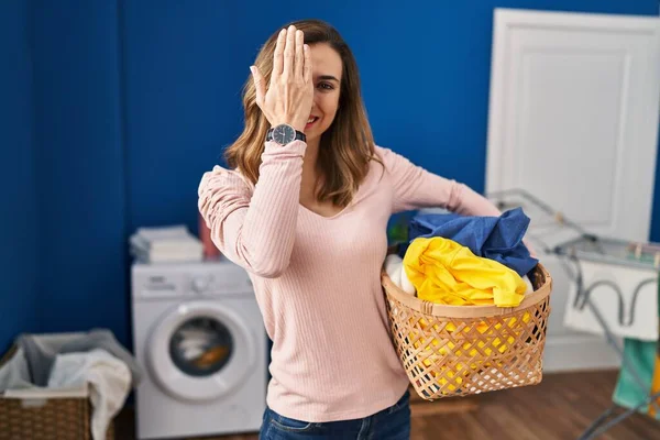 Young Woman Holding Laundry Basket Covering One Eye Hand Confident — Stok fotoğraf