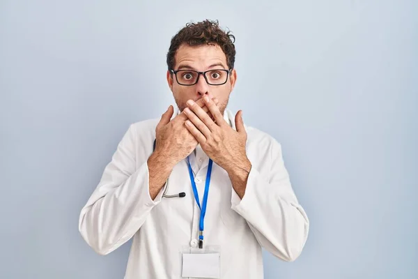 医師の制服を着た若いヒスパニック系の男性と聴診器は間違いのために手で口をカバーショックを受けました 秘密の概念 — ストック写真
