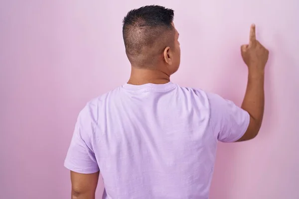 Young Hispanic Man Standing Pink Background Posing Backwards Pointing Ahead — Stock fotografie