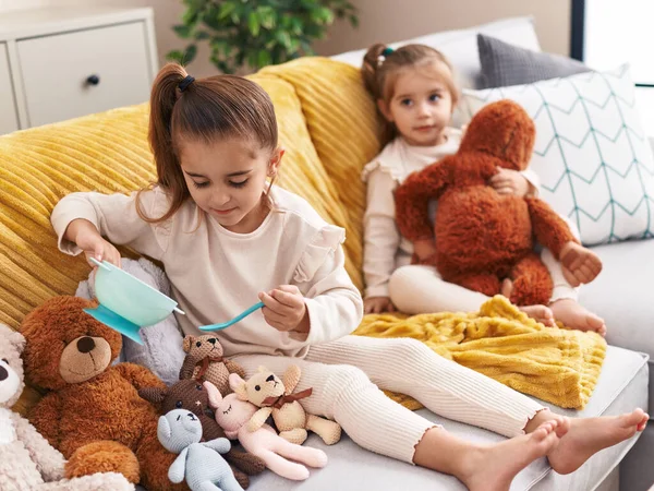 Dvě Děti Hrají Panenkami Sedícími Doma Gauči — Stock fotografie