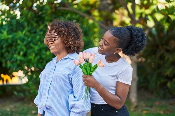 非洲裔美国妇女母女惊喜地在公园里放着一束鲜花 — 图库照片