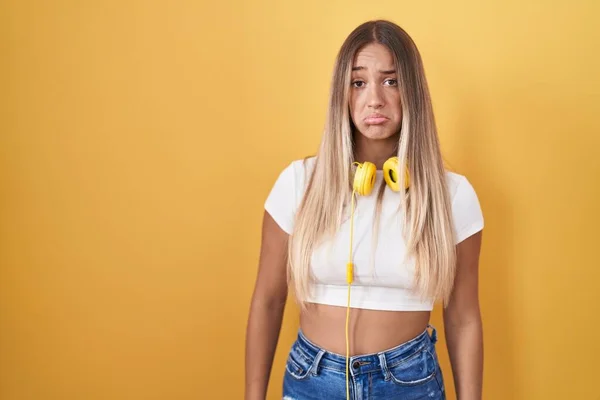 Young Blonde Woman Standing Yellow Background Wearing Headphones Depressed Worry — Zdjęcie stockowe