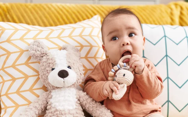 愛らしいHispanic幼児Bittingおもちゃ座っています上のソファにホーム — ストック写真