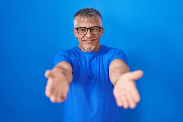 Hispanic Man Grey Hair Standing Blue Background Smiling Cheerful Offering — 스톡 사진