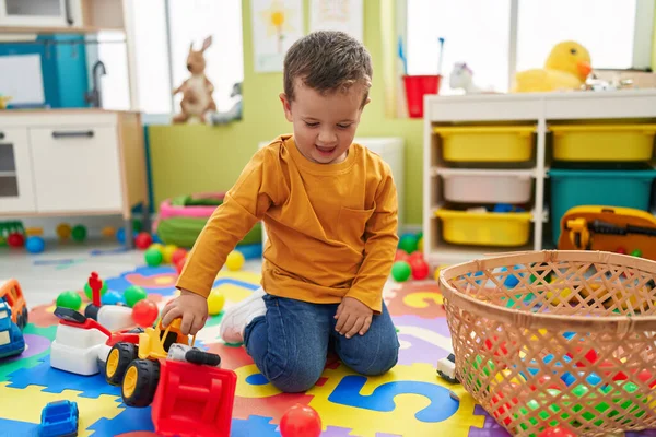 愛らしいです白人男の子遊びますトラクターおもちゃで床に座って幼稚園 — ストック写真