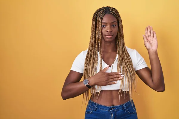 African American Woman Braided Hair Standing Yellow Background Swearing Hand — Stockfoto