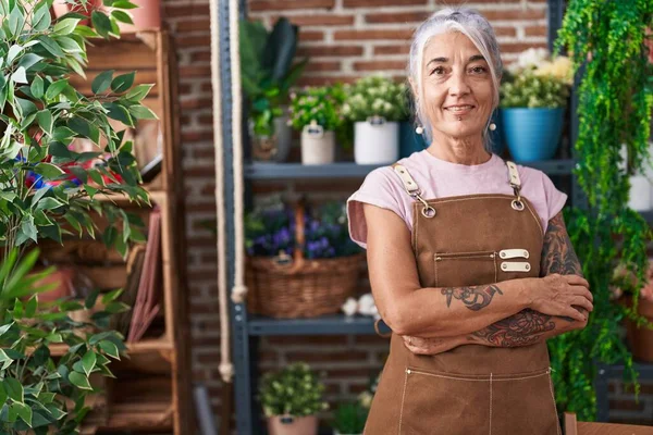 Middle age grey-haired woman florist smiling confident standing with arms crossed gesture at florist