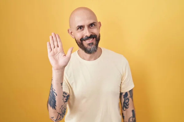 Hispanic Man Tattoos Standing Yellow Background Waiving Saying Hello Happy — Foto Stock