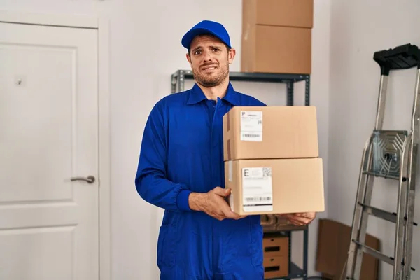 Young Hispanic Man Working Moving Service Holding Boxes Clueless Confused — Stockfoto