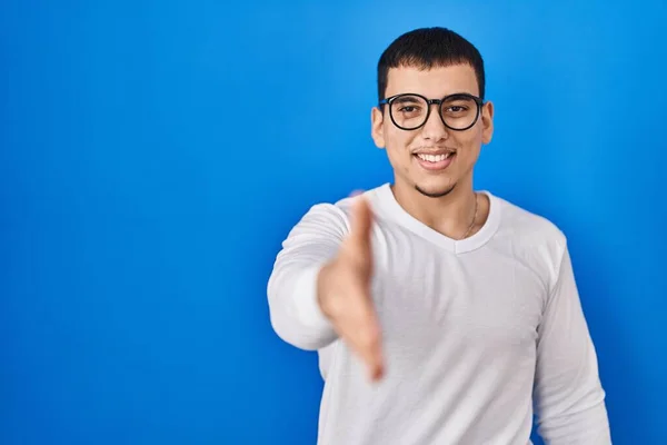 年轻的阿拉伯男子身穿休闲的白色衬衫 戴着眼镜 友善地微笑 握手致意和欢迎 成功的商业 — 图库照片