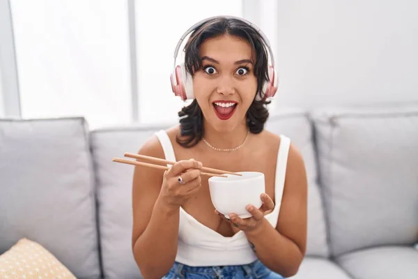 Young Hispanic Woman Eating Asian Food Using Chopsticks Afraid Shocked — Stockfoto