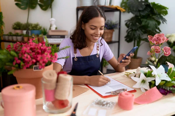Young African American Woman Florist Using Smartphone Writing Document Flower — Stockfoto