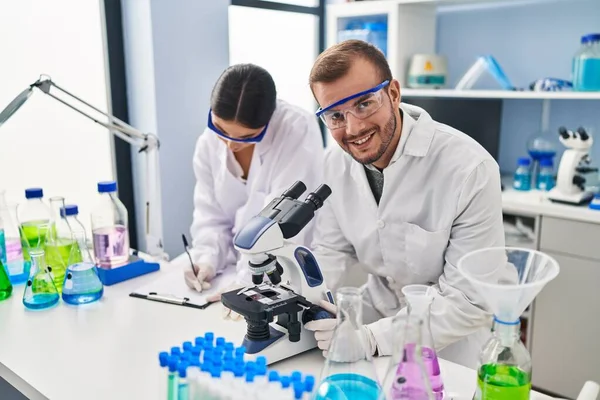 Man Woman Scientist Partners Working Using Microscope Writing Clipboard Laboratory — Stockfoto