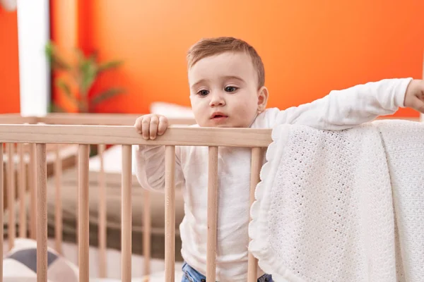 可爱的高加索婴儿站在摇篮上 在卧室里表情轻松 — 图库照片