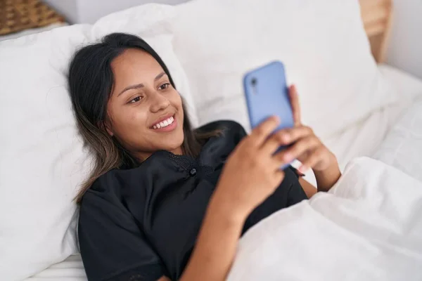 Young Hispanic Woman Using Smartphone Lying Bed Bedroom — 图库照片