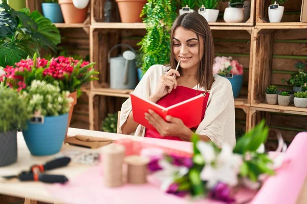 Young Beautiful Hispanic Woman Florist Smiling Confident Reading Notebook Flower — Stock fotografie
