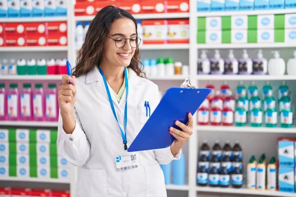Young Beautiful Hispanic Woman Pharmacist Holding Clipboard Pen Pharmacy — Zdjęcie stockowe