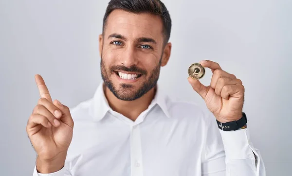Handsome Hispanic Man Holding Polkadot Cryptocurrency Coin Smiling Happy Pointing — Stock Photo, Image