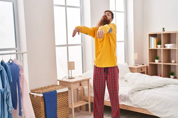 Young redhead man somnambulist sleepwalking at bedroom
