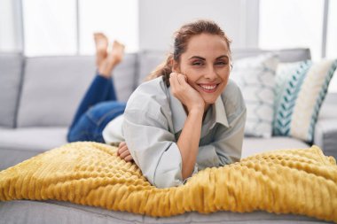 Young woman smiling confident lying on sofa at home